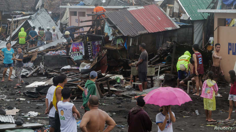 Residents stand among their damaged houses after Typhoon Kammuri hit Legazpi City, Albay